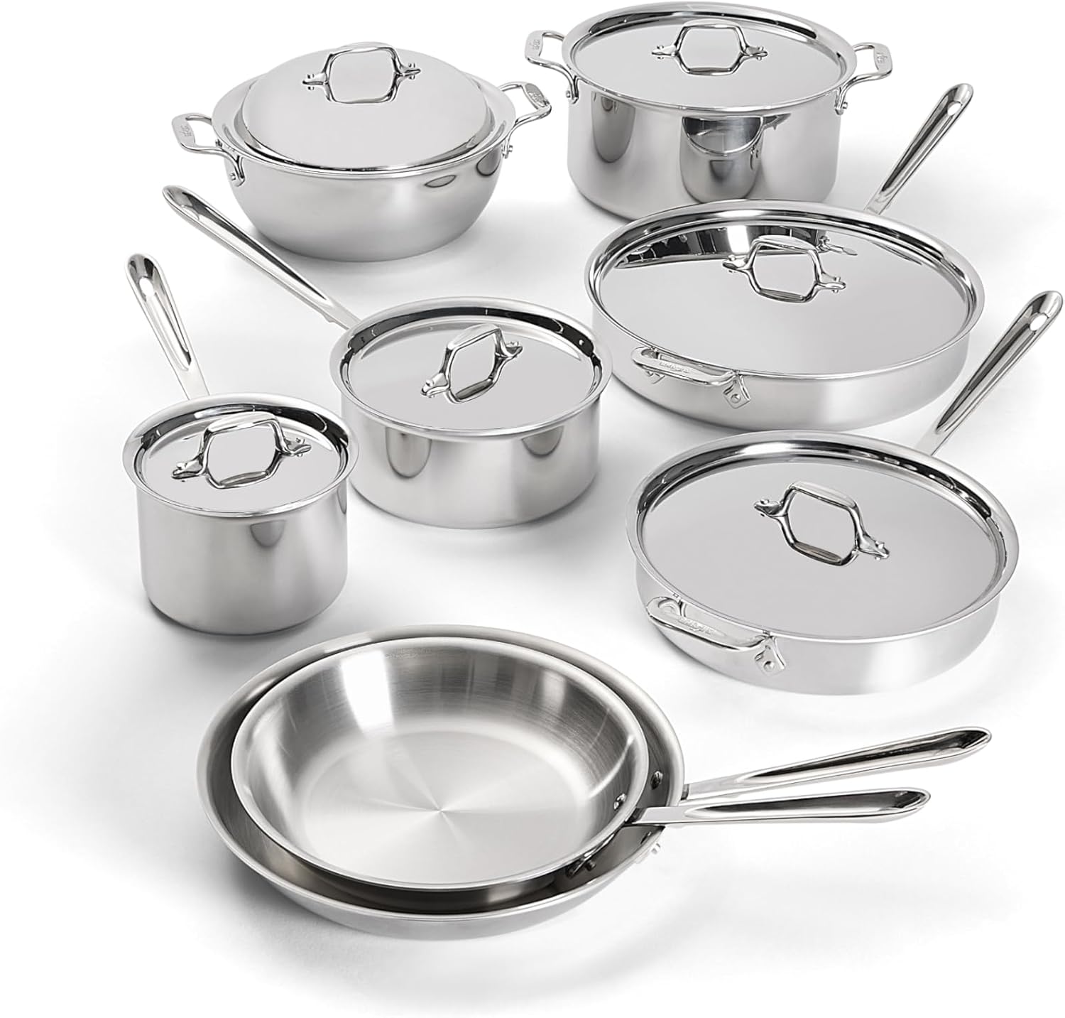 The All-Clad D3 14-Piece Stainless Steel Cookware Set arranged on a kitchen counter, showing the polished exteriors and riveted handles
