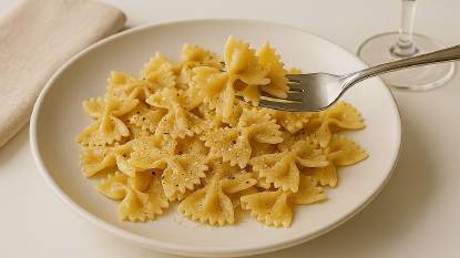 Farfalle pasted cooked and served on a white plate with a fork picking some up