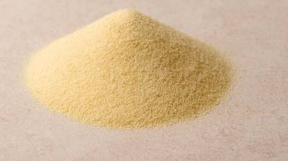 Uncooked Semolina in a pile on a kitchen surface 